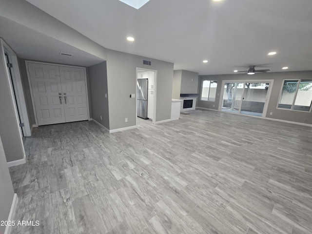 unfurnished living room featuring light wood-style floors, recessed lighting, and baseboards