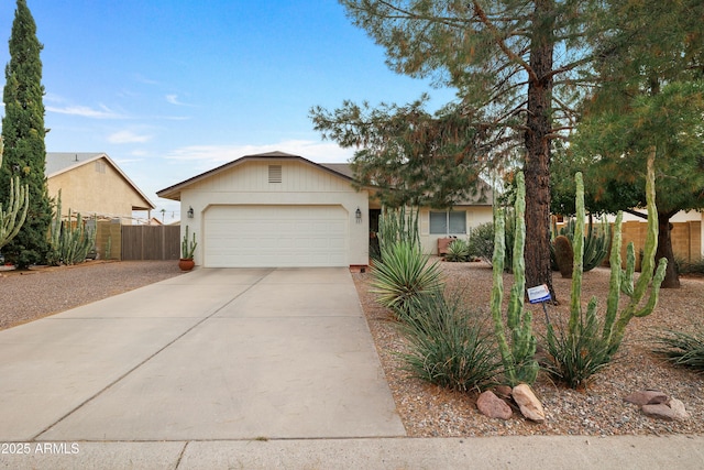 ranch-style house with an attached garage, driveway, and fence