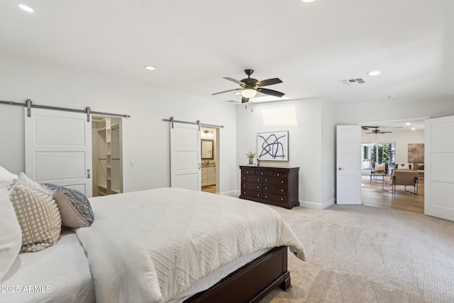 4920 E Osborn Rd, Phoenix, AZ 85018 - bedroom with a barn door, recessed lighting, light carpet, baseboards, and ensuite bathroom
