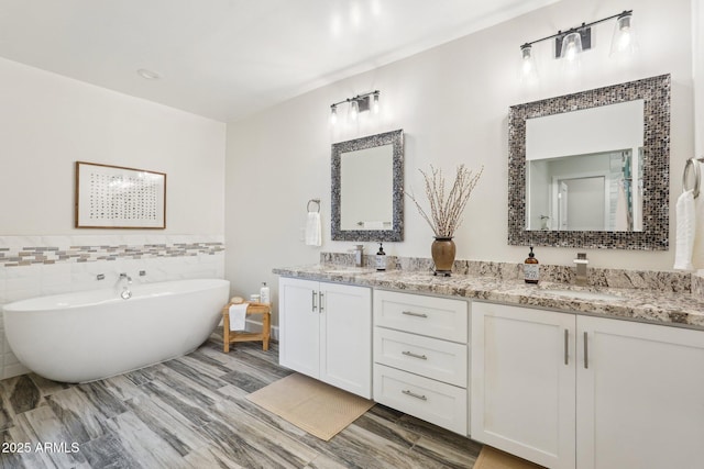4920 E Osborn Rd, Phoenix, AZ 85018 - bathroom with double vanity, a freestanding tub, and tile walls