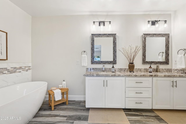 4920 E Osborn Rd, Phoenix, AZ 85018 - bathroom with double vanity, wood finished floors, a soaking tub, tile walls, and baseboards