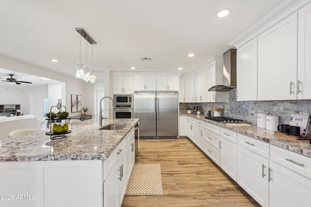4920 E Osborn Rd, Phoenix, AZ 85018 - kitchen featuring appliances with stainless steel finishes, wall chimney range hood, a sink, white cabinetry, and a ceiling fan