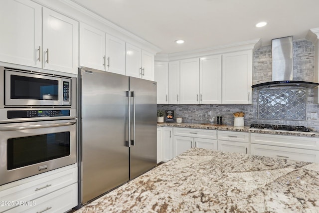 4920 E Osborn Rd, Phoenix, AZ 85018 - kitchen featuring appliances with stainless steel finishes, wall chimney range hood, white cabinets, decorative backsplash, and recessed lighting