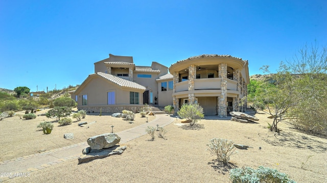 3903 E Melody Dr, Phoenix, AZ 85042 - view of front facade with a balcony, stone siding, stucco siding, a tiled roof, and a ceiling fan