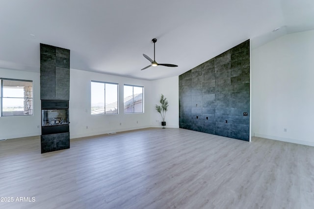 3903 E Melody Dr, Phoenix, AZ 85042 - unfurnished living room with lofted ceiling, a ceiling fan, light wood-style flooring, a tile fireplace, and baseboards
