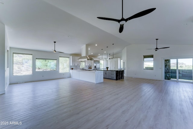 3903 E Melody Dr, Phoenix, AZ 85042 - unfurnished living room with a ceiling fan, vaulted ceiling, baseboards, and light wood-style floors