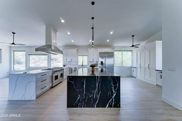 3903 E Melody Dr, Phoenix, AZ 85042 - kitchen with premium appliances, a ceiling fan, island exhaust hood, a kitchen island, and decorative backsplash