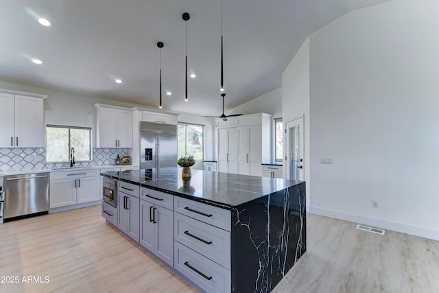 3903 E Melody Dr, Phoenix, AZ 85042 - kitchen featuring built in appliances, a sink, light wood finished floors, tasteful backsplash, and white cabinetry