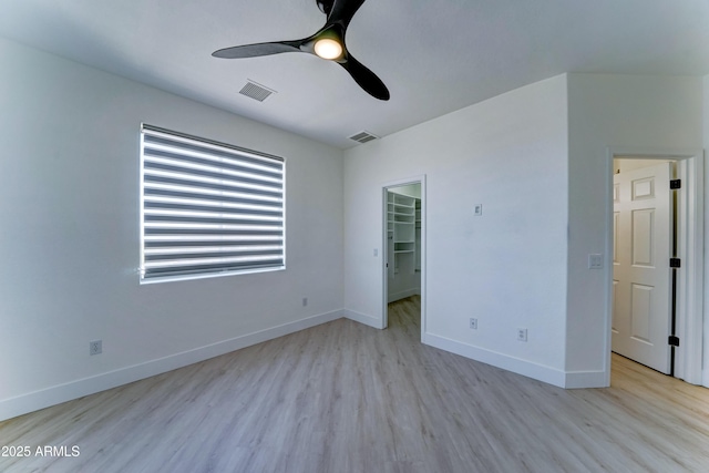 3903 E Melody Dr, Phoenix, AZ 85042 - unfurnished bedroom with light wood-style flooring, baseboards, a walk in closet, a ceiling fan, and a closet