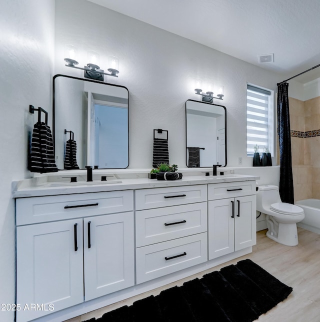 3903 E Melody Dr, Phoenix, AZ 85042 - full bath with double vanity, toilet, wood finished floors, and shower / bath combo with shower curtain