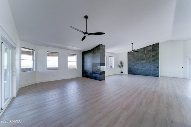 3903 E Melody Dr, Phoenix, AZ 85042 - unfurnished living room featuring a ceiling fan, vaulted ceiling, light wood-style flooring, a fireplace, and baseboards