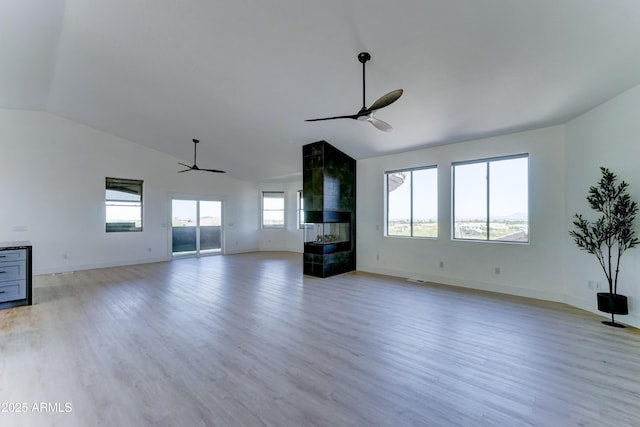 3903 E Melody Dr, Phoenix, AZ 85042 - unfurnished living room with a ceiling fan, light wood-style flooring, baseboards, a tile fireplace, and high vaulted ceiling