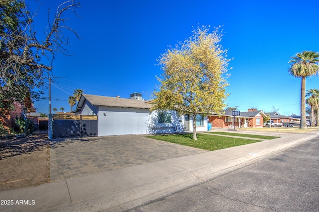 ranch-style house with a garage and a front lawn