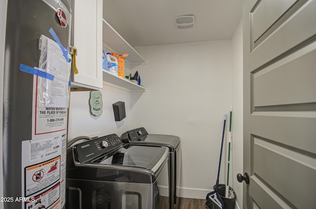 washroom with cabinets, hardwood / wood-style flooring, gas water heater, and washer and dryer