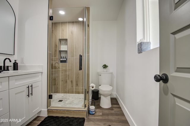 bathroom with vanity, hardwood / wood-style floors, toilet, and walk in shower