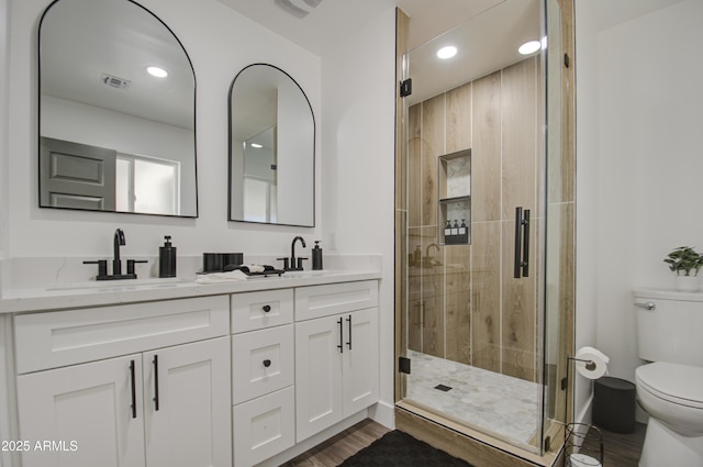 bathroom with vanity, wood-type flooring, an enclosed shower, and toilet