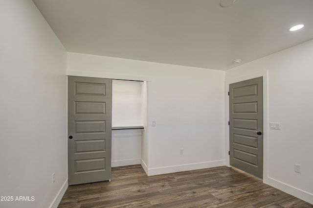 unfurnished bedroom with dark hardwood / wood-style floors and a closet