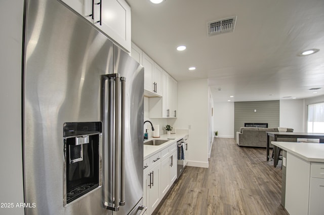 kitchen featuring white cabinetry, stainless steel appliances, dark hardwood / wood-style flooring, and sink