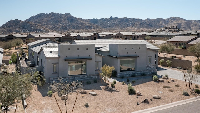 pueblo revival-style home featuring a mountain view and stucco siding