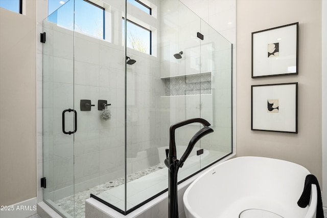 bathroom with a freestanding tub and a shower stall