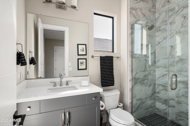 bathroom with a stall shower, vanity, and toilet