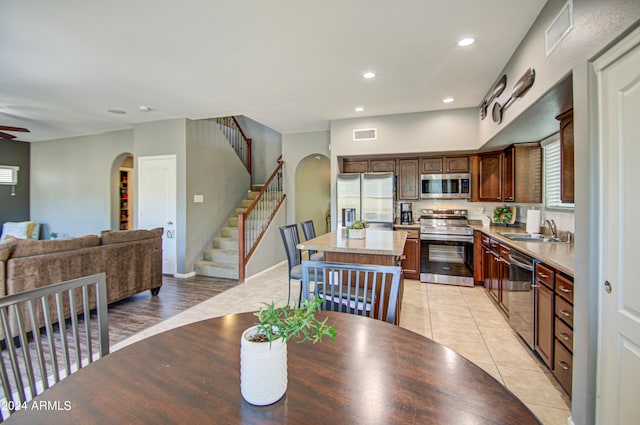 dining space featuring light hardwood / wood-style flooring, sink, and ceiling fan