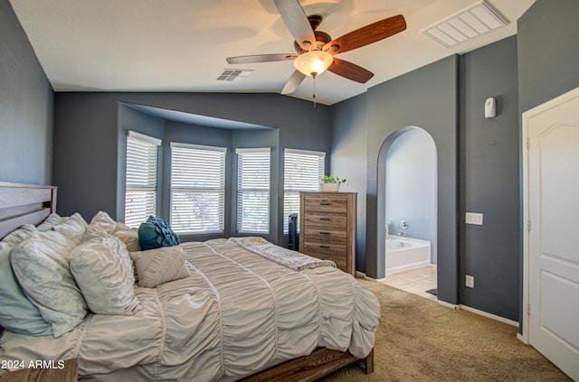 bedroom with vaulted ceiling, light carpet, ensuite bathroom, and ceiling fan