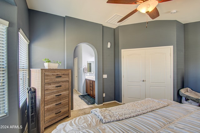 tiled bedroom with ceiling fan, a closet, and ensuite bath