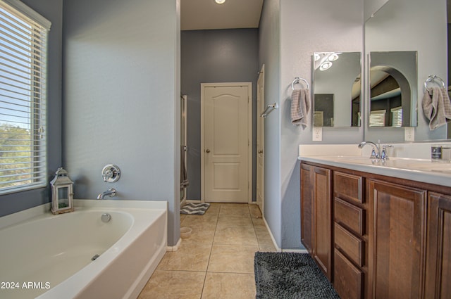 bathroom with vanity, a bath, a healthy amount of sunlight, and tile patterned flooring