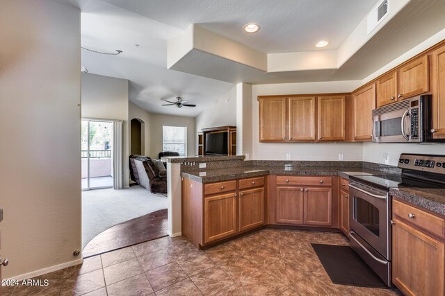 kitchen with visible vents, brown cabinetry, appliances with stainless steel finishes, open floor plan, and a peninsula