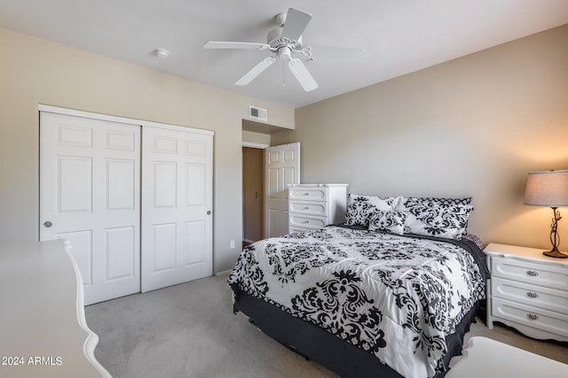 bedroom with ceiling fan, light colored carpet, and a closet