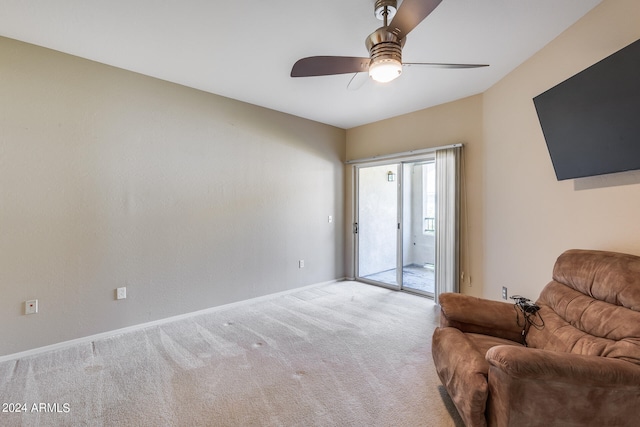 living area with ceiling fan and carpet