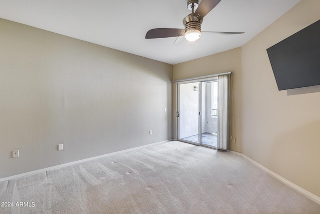 carpeted empty room featuring a ceiling fan and baseboards