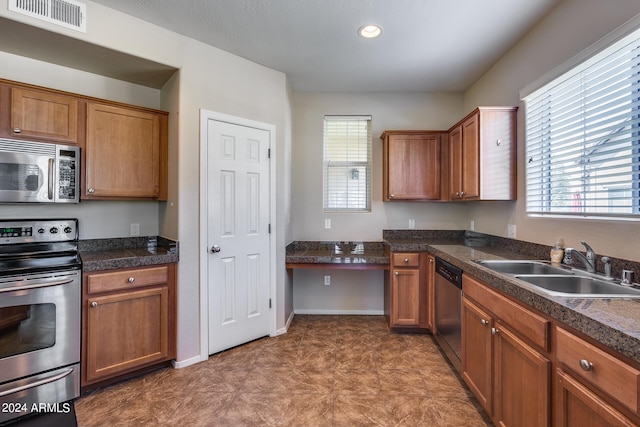 kitchen with sink, stainless steel appliances, tile patterned flooring, and a healthy amount of sunlight