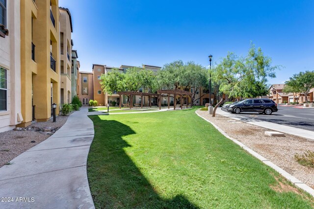 view of home's community featuring a yard and a pergola