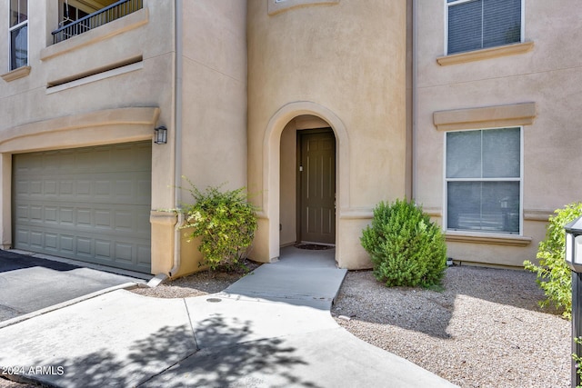 doorway to property featuring a garage and stucco siding