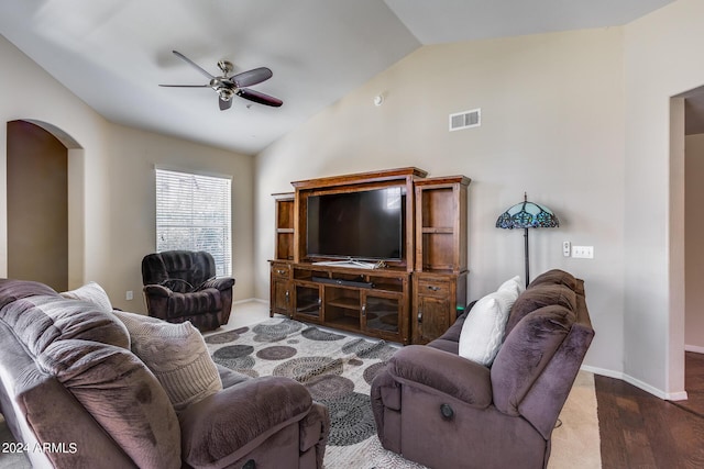 living area featuring ceiling fan, arched walkways, visible vents, baseboards, and vaulted ceiling