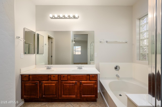 bathroom with tile patterned flooring, vanity, ceiling fan, and a bath