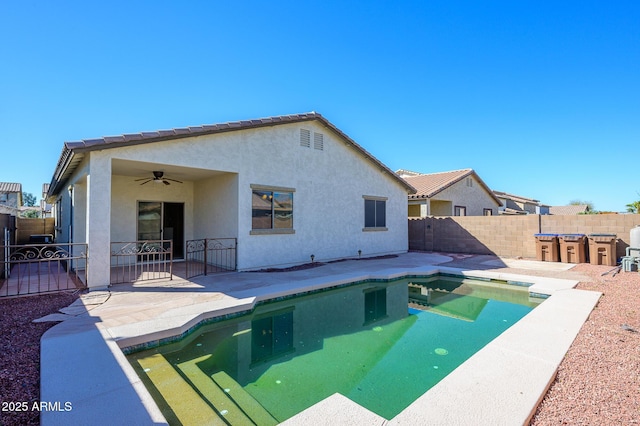 view of swimming pool with a patio area, ceiling fan, and a bar