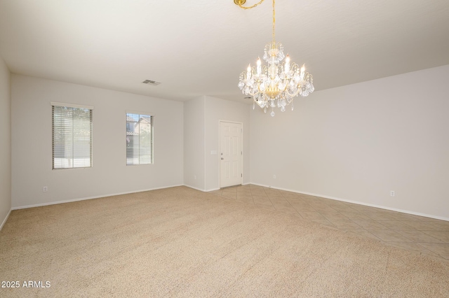 tiled spare room with an inviting chandelier