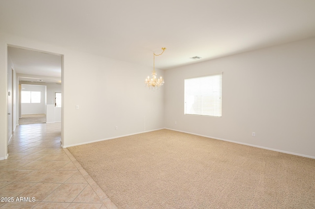 spare room with light tile patterned floors and an inviting chandelier