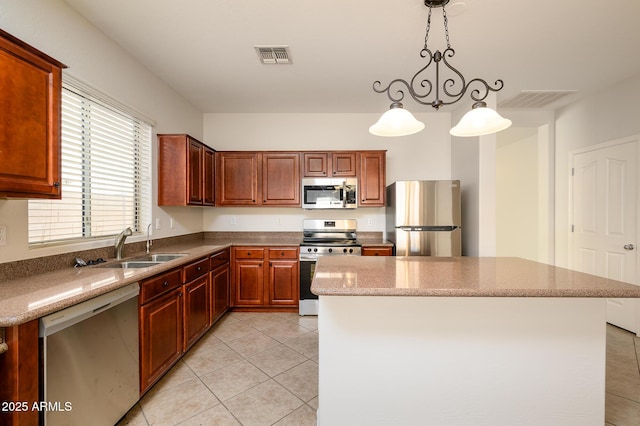 kitchen with light stone counters, stainless steel appliances, a center island, hanging light fixtures, and light tile patterned flooring