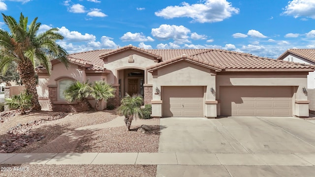 mediterranean / spanish-style house with a garage, concrete driveway, a tiled roof, and stucco siding