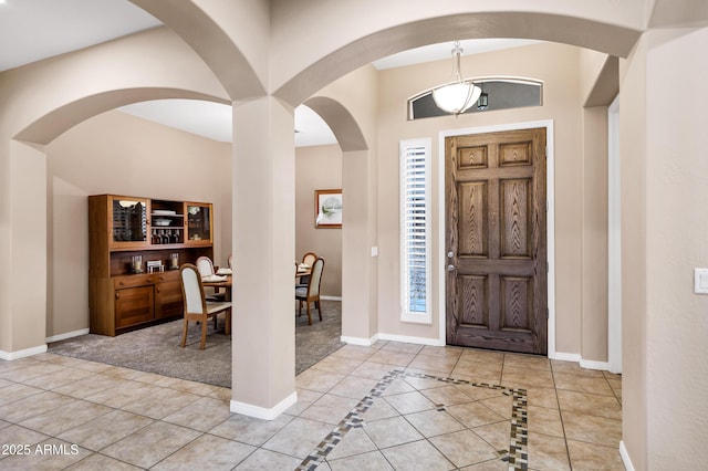 entryway with light tile patterned floors and baseboards