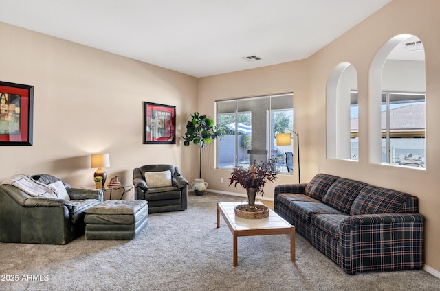 carpeted living room with visible vents and baseboards