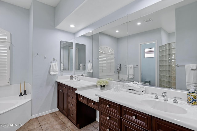 bathroom featuring a garden tub, toilet, vanity, baseboards, and tile patterned floors