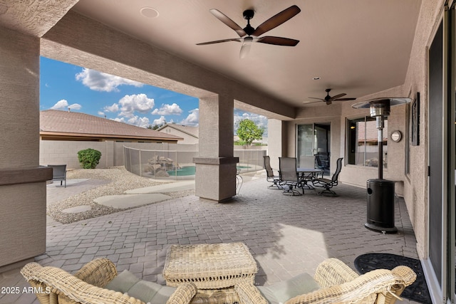 view of patio / terrace featuring outdoor dining area, a fenced backyard, a ceiling fan, and a fenced in pool