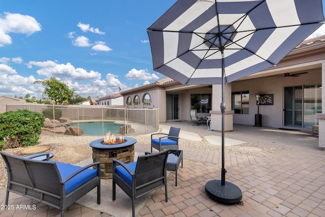 view of patio / terrace featuring a fenced in pool, fence, a fire pit, and a ceiling fan