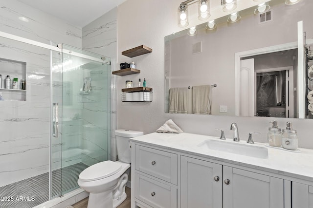 bathroom featuring an enclosed shower, vanity, and toilet