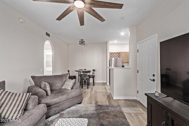 living room with ceiling fan and light wood-type flooring